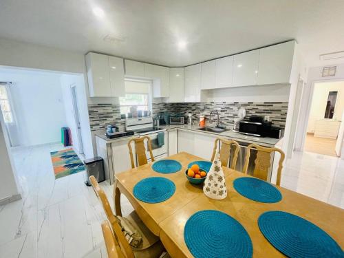 a kitchen with a wooden table with blue plates on it at Bright & Cozy Family Home Near Dania Beach in Dania Beach