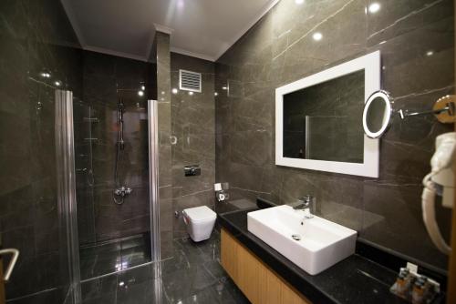 Un baño con lavabo, ducha e inodoro. en The Berussa Hotel, en Bursa