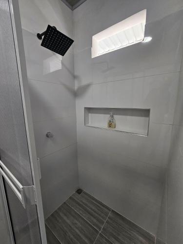 a white bathroom with a shower and a window at La Sucursal del Cielo in Manaure Balcón del Cesar