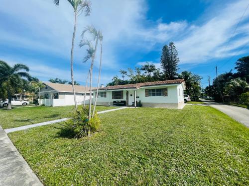 a house with a palm tree in the yard at Bright & Cozy Family Home Near Dania Beach in Dania Beach