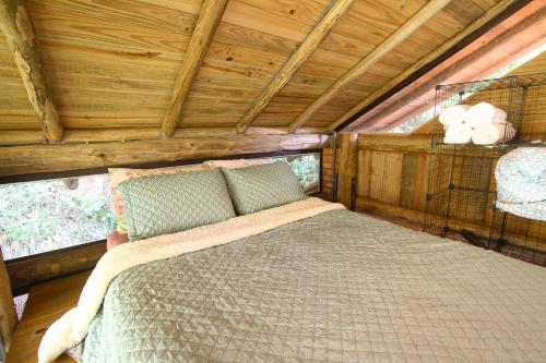 a bedroom with a bed in a cabin at Suíte com cachoeira no quintal in Antônio Carlos