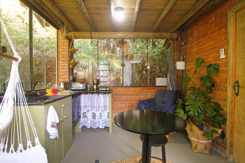 a small kitchen with a table in a room at Suíte com cachoeira no quintal in Antônio Carlos