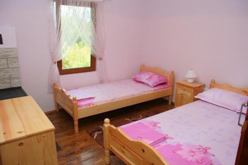 1 dormitorio con 2 camas y ventana en Lazarovata House en Rebrevtsi