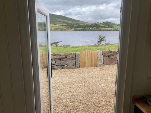 una puerta abierta con vistas a una masa de agua en Lakeside Cabin, en Galway