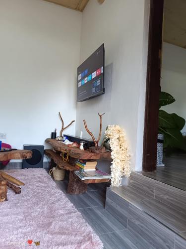a living room with a table and a tv on a wall at Hellenas Gem in Ukunda