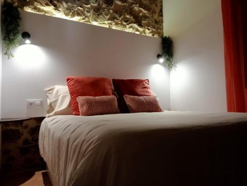 a bedroom with a bed with red pillows on it at Apartamentos Muralla Sacra in Sober
