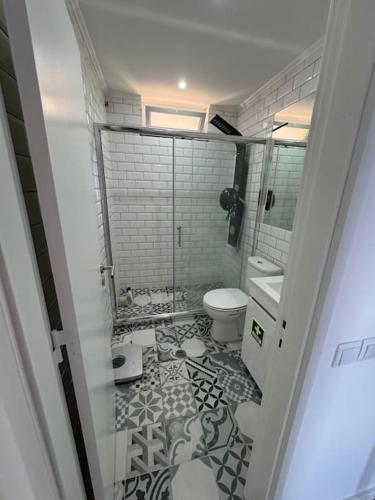 a bathroom with a toilet and a tiled floor at Beachfront Amazing Location - 19th Hole in Ponta Delgada