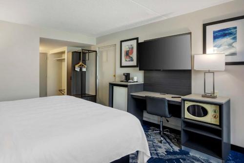 a hotel room with a bed and a desk and a tv at Best Western Rutgers University Hotel in East Brunswick