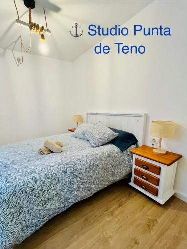 a bedroom with a bed and a table with a lamp at El Castillito Studios in Buenavista del Norte