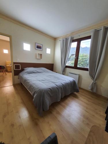 une chambre avec un lit et une grande fenêtre dans l'établissement Roseraie, à Moissac