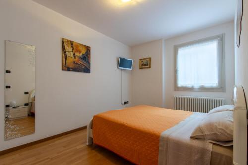 una camera da letto bianca con un letto e una finestra di Casa La Corte a Rovereto