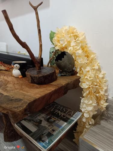a table with flowers on it with a magazine at Hellenas Gem in Ukunda