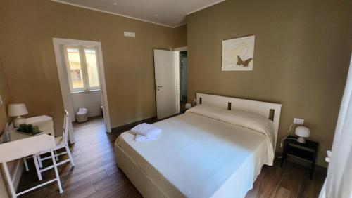 a bedroom with a bed and a table and a window at Casa Fraeli in Pozzuoli