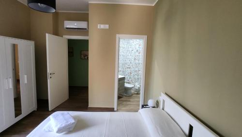 a bedroom with a bed and a bathroom with a toilet at Casa Fraeli in Pozzuoli