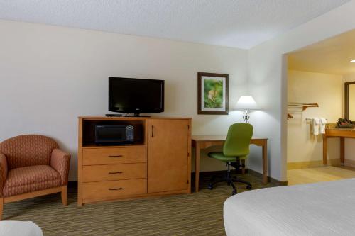 a hotel room with a bed and a desk with a television at Best Western Paint Pony Lodge in Show Low