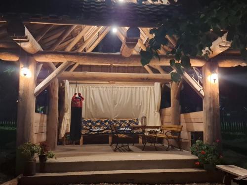 a wooden house with a bench and a table at Domek, Apartamenty i pokoje Willa Elita in Kościelisko