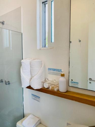 a bathroom with a shelf with towels and a mirror at Studios Downtown Cancun in Cancún