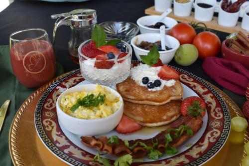 a plate of breakfast food with pancakes and fruit at Stone Manor Boutique Inn in Britain