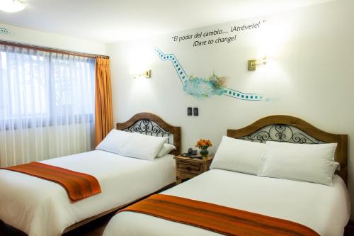 a bedroom with two beds and a sign on the wall at Casa San Blas Cusco Exquisite By Xima in Cusco