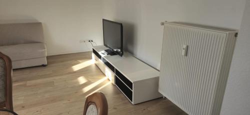 a living room with a flat screen tv on a dresser at Ferienwohnung Hausnummer 1, Kontaktloser Self check-in in Zweibrücken