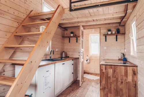 a kitchen with a staircase in a tiny house at JEZIORAKI Wyjątkowe domki 500m od jeziora Nowa Jedlanka in Uścimów