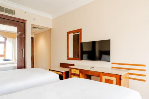 a hotel room with two beds and a television at Om Kolthoom Hotel in Cairo