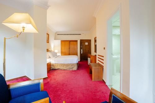 a hotel room with a bed and a red carpet at Om Kolthoom Hotel in Cairo