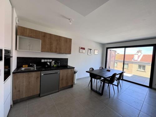 une cuisine avec une table et une salle à manger avec une table et des chaises dans l'établissement Magnifique T2-Climatisé avec terrasse-Catalans, à Marseille