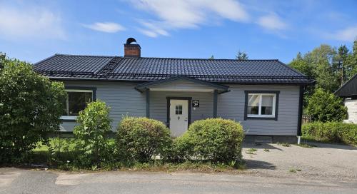a blue house with a chimney on top of it at Gästhuset 32 in Vansbro