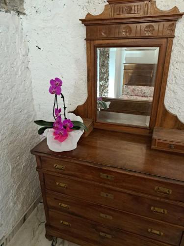 a dresser with a mirror and a flower on it at Casa alla Cascata in Cunardo