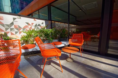 a group of orange chairs and a table on a patio at Golden Tower Express Nações Unidas by Fênix Hotéis in Sao Paulo