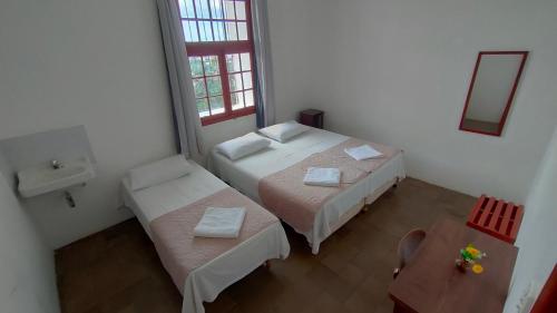 a small room with two beds and a sink at Pousada Convento da Conceição in Olinda