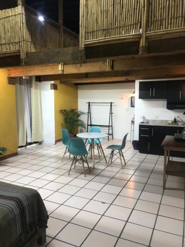 a room with a table and chairs and a kitchen at Hostal Luz de Luna Nuyoo in Oaxaca City
