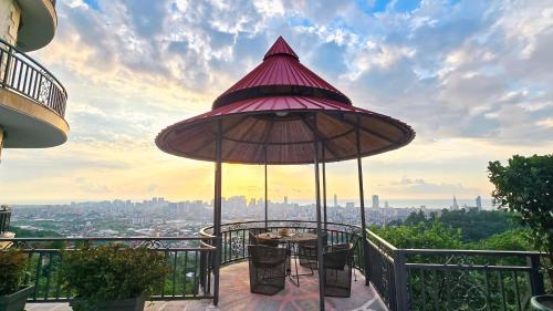 a patio with a table and an umbrella on a balcony at Hillside Inn in Batumi
