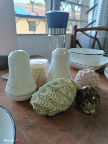 two white vases sitting on a wooden table at Hellenas Gem in Ukunda