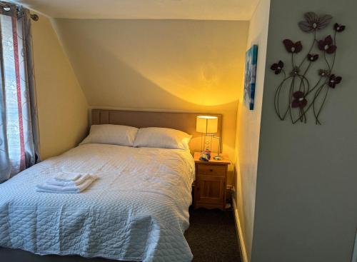 a bedroom with a bed with a lamp on a night stand at Stylish Modern 1-Bed Apartment in Prime Solihull Town Centre in Solihull