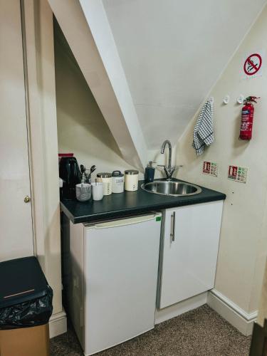 a small kitchen with a sink and a counter at Stylish Modern 1-Bed Apartment in Prime Solihull Town Centre in Solihull