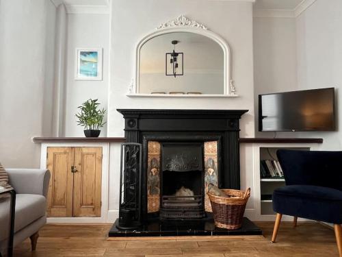 sala de estar con chimenea y espejo en Luxury holiday home in Brixham, en Brixham