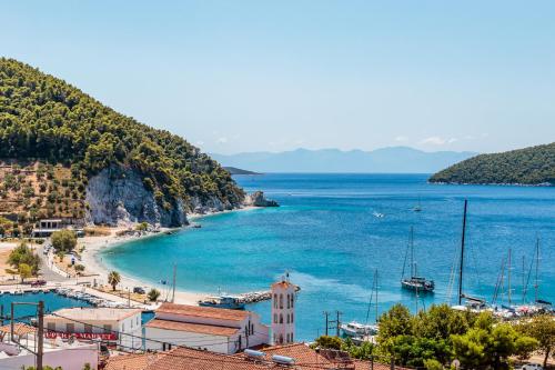 a view of a beach with a church and the ocean at Ioanna House in Skopelos Town