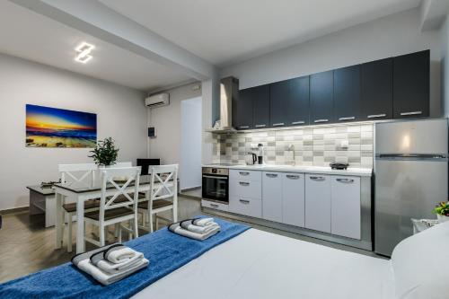 a kitchen with white cabinets and a dining table at Ioanna House in Skopelos Town