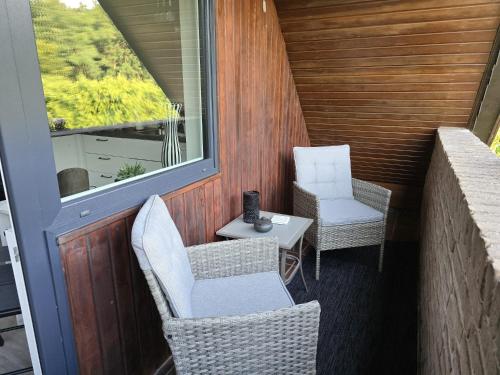 a small balcony with two chairs and a table at Ferienwohnung Morgensonne Mölln in Mölln