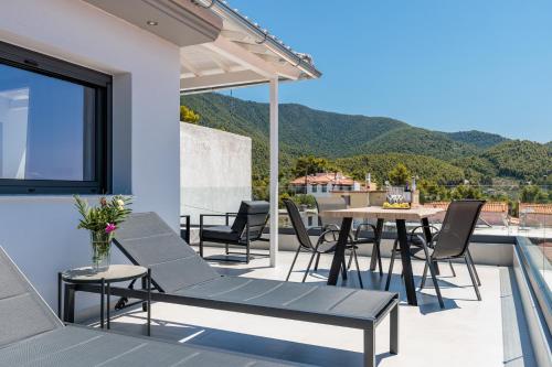 a patio with a table and chairs on a balcony at Ioanna House in Skopelos Town