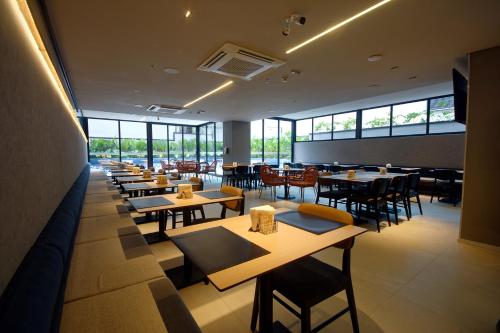 a restaurant with tables and chairs and windows at Golden Tower Express Nações Unidas by Fênix Hotéis in Sao Paulo