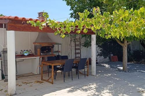 a wooden table and chairs under a pergola at Casa 2 Jardins in Olaia