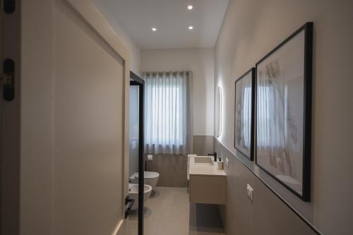 a bathroom with two sinks and a toilet in it at Momacasa b&b in Roseto degli Abruzzi