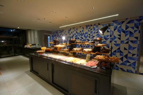 a bakery with a buffet of food on a counter at Golden Tower Express Nações Unidas by Fênix Hotéis in Sao Paulo