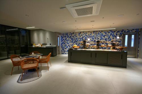 a restaurant with a counter with chairs and a table at Golden Tower Express Nações Unidas by Fênix Hotéis in Sao Paulo