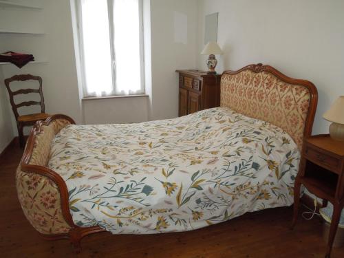 a bedroom with a bed with a floral bedspread at Chez Pauline, Gavray. House with secure parking, Wi-Fi & garage. in Gavray
