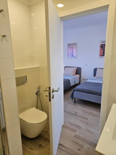 a bathroom with a toilet and two beds at Ideal Bubble House in Faro