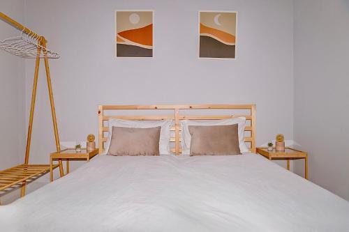 a bedroom with a large white bed with two tables at Cozy Studio in the City Center in Thessaloniki